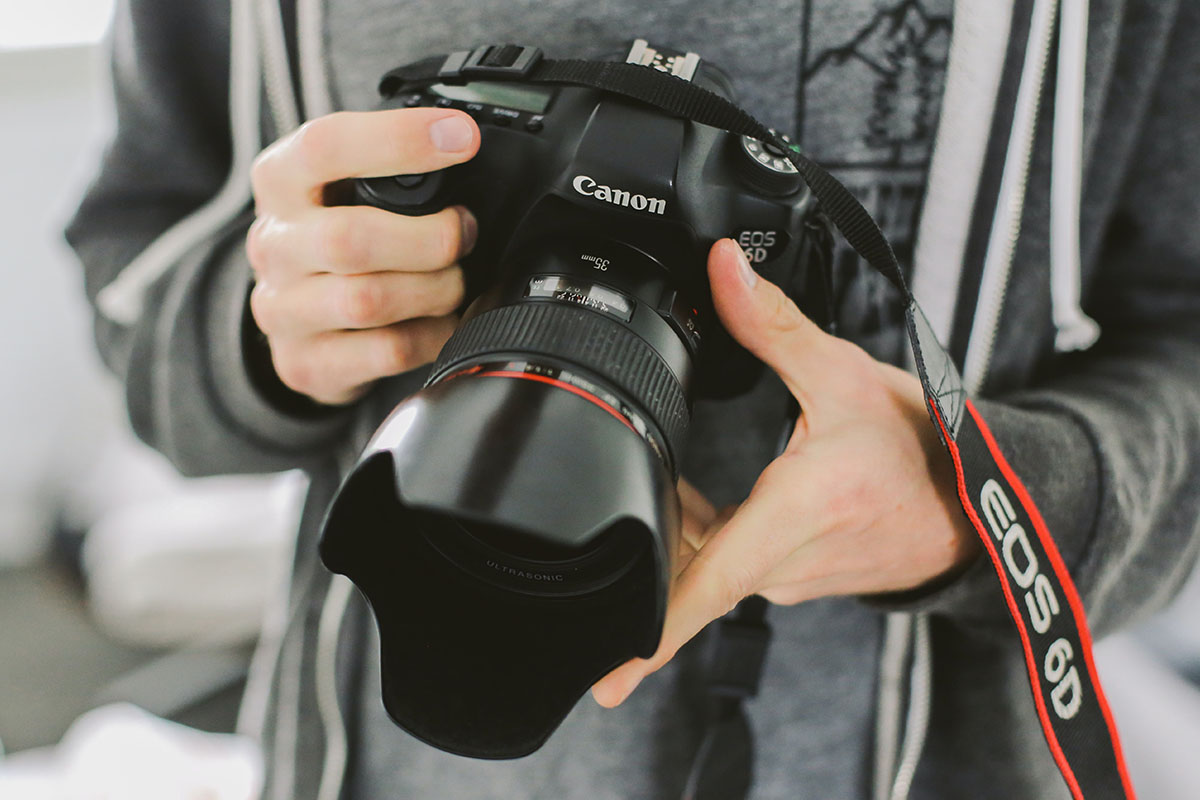 A person holding a Canon camera