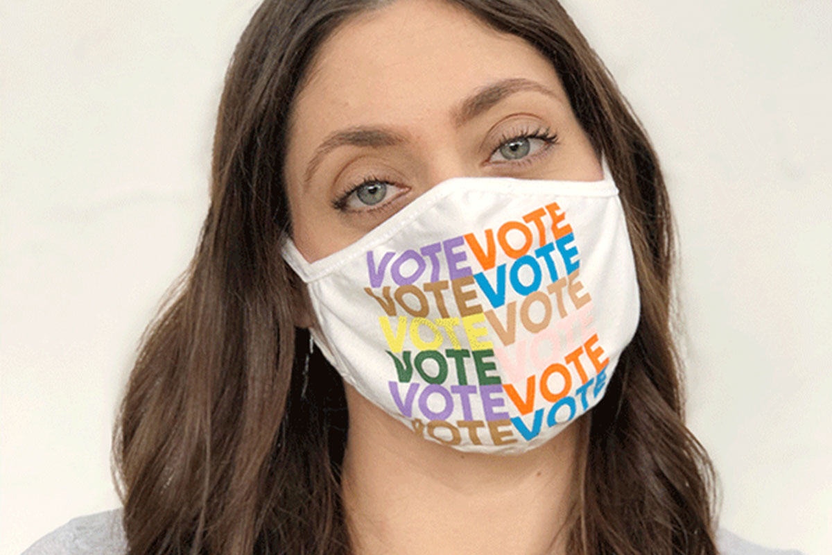 A person wearing a face mask that repeats the word "VOTE" on it. 